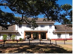 The Cloisters, a white building with a covered entrance shaded by large trees